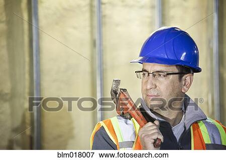 Stock Photo - Caucasian worker using wrench. Fotosearch