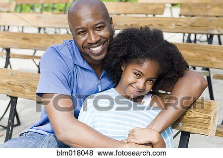 Father and daughter smiling on park bench View Large Photo Image Stock Photo - Father and daughter smiling on park bench. Fotosearch