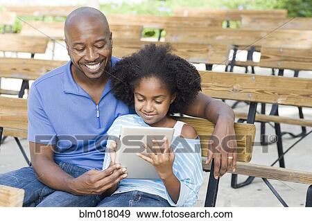 Stock Photo - Father and daughter using tablet computer. Fotosearch