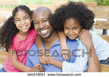 Father and daughters smiling together View Large Photo Image Stock Image - Father and daughters smiling together. Fotosearch