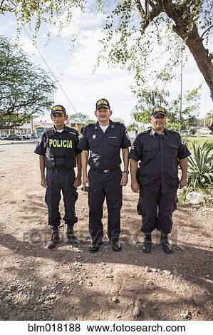Stock Photo - Hispanic police standing in field. Fotosearch