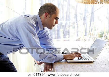 Mixed race businessman using laptop in office View Large Photo Image Picture - Mixed race businessman using laptop in office. Fotosearch