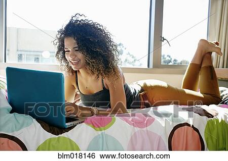 Mixed race college student using laptop in dorm View Large Photo Image Stock Photograph - Mixed race college student using laptop in dorm. Fotosearch