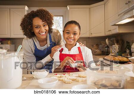 Stock Photograph - Mother and daughter baking in kitchen. Fotosearch