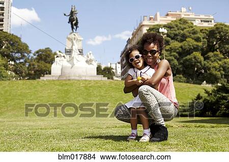 Mother and daughter smiling in park View Large Photo Image Picture - Mother and daughter smiling in park. Fotosearch