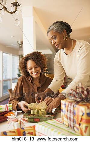 Mother and daughter wrapping Christmas presents View Large Photo Image Stock Image - Mother and daughter wrapping Christmas presents. Fotosearch