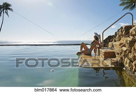 Picture - Pacific Islander woman relaxing in pool. Fotosearch