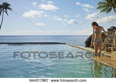 Stock Photo - Pacific Islander woman relaxing in pool. Fotosearch