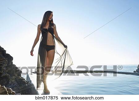 Stock Photography - Pacific Islander woman walking on wooden railing. Fotosearch
