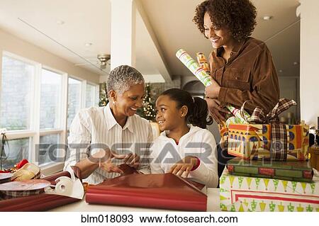 Three generations of women wrapping Christmas presents View Large Photo Image Stock Image - Three generations of women wrapping Christmas presents. Fotosearch