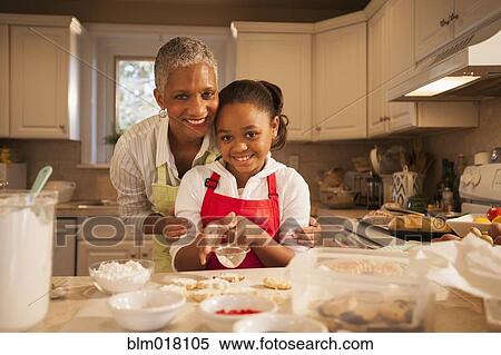 Stock Photography - Woman and granddaughter baking in kitchen. Fotosearch