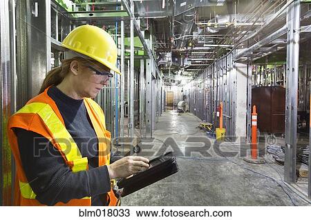 Stock Image - Worker using tablet computer on site. Fotosearch