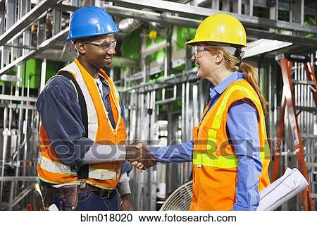 Workers shaking hands on site View Large Photo Image Stock Image - Workers shaking hands on site. Fotosearch