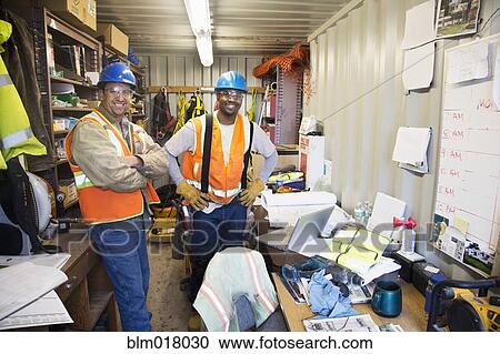Stock Image - Workers smiling in office on site. Fotosearch