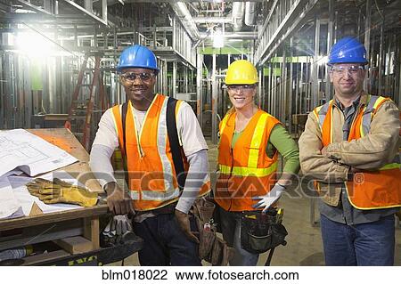 Stock Image - Workers smiling on site. Fotosearch