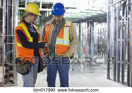 Stock Image - Workers talking on site. Fotosearch