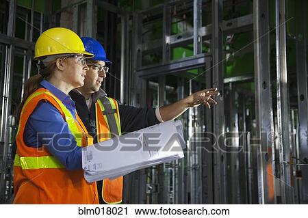 Workers using blueprints on site View Large Photo Image Stock Image - Workers using blueprints on site. Fotosearch