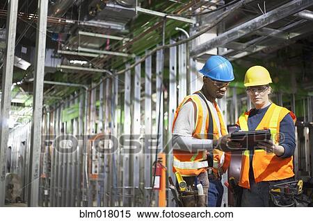 Workers using tablet computer on site View Large Photo Image Stock Photography - Workers using tablet computer on site. Fotosearch