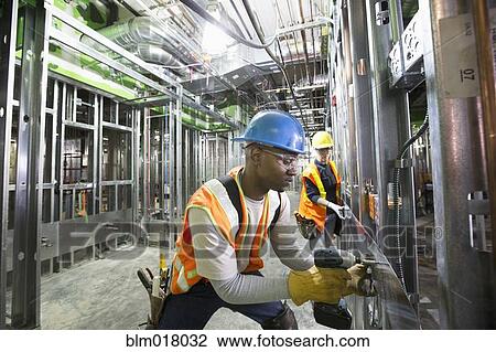 Stock Image - Workers working with metal on site. Fotosearch