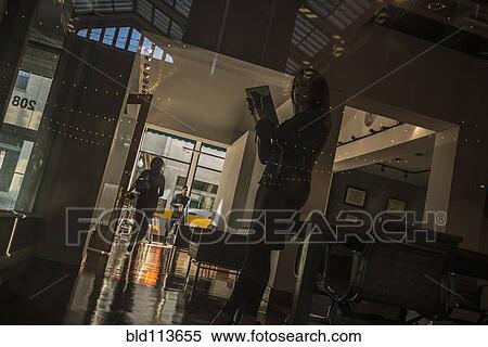 Stock Photography - African American woman reading in office. Fotosearch