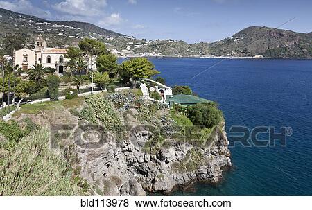 Building on cliff overlooking ocean, Isle of Lipari, Sicily, Italy View Large Photo Image Stock Photo - Building on cliff overlooking ocean, Isle of Lipari, Sicily, Italy. Fotosearch