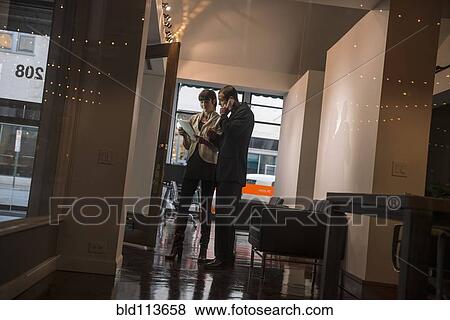 Caucasian business people talking in hallway View Large Photo Image Stock Photo - Caucasian business people talking in hallway. Fotosearch