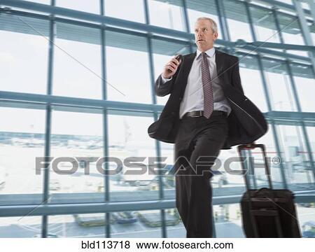 Caucasian businessman rushing through airport View Large Photo Image Stock Photo - Caucasian businessman rushing through airport. Fotosearch