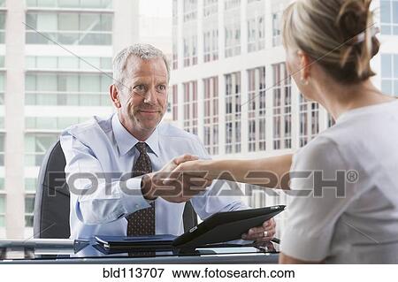 Caucasian businessman shaking hands with client View Large Photo Image Stock Photo - Caucasian businessman shaking hands with client. Fotosearch