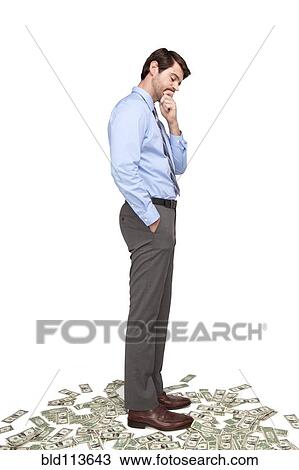 Caucasian businessman standing on money View Large Photo Image Stock Image - Caucasian businessman standing on money. Fotosearch