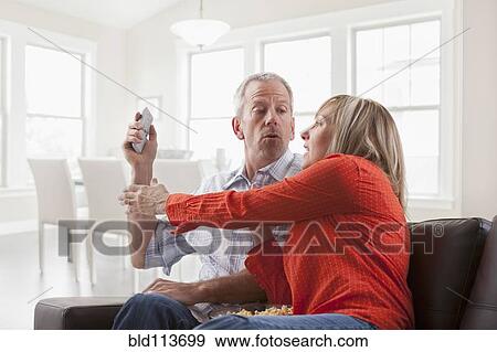 Caucasian couple fighting over remote control View Large Photo Image Stock Photo - Caucasian couple fighting over remote control. Fotosearch
