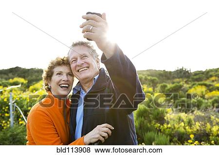 Caucasian couple taking picture outdoors View Large Photo Image Stock Photo - Caucasian couple taking picture outdoors. Fotosearch