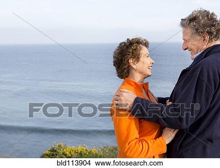 Picture - Caucasian couple walking on beach. Fotosearch
