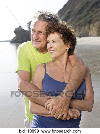 Stock Photo - Caucasian couple walking on beach. Fotosearch
