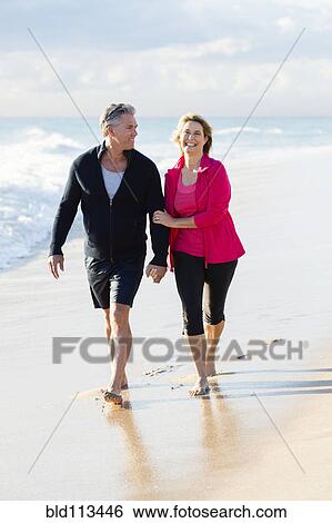 Caucasian couple walking on beach View Large Photo Image Stock Photograph - Caucasian couple walking on beach. Fotosearch