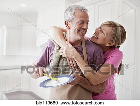 Caucasian couple washing dishes in kitchen View Large Photo Image Stock Photo - Caucasian couple washing dishes in kitchen. Fotosearch