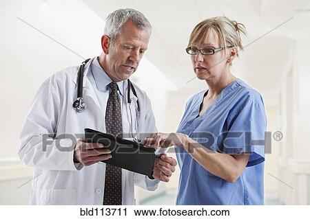 Caucasian doctor and nurse talking View Large Photo Image Stock Image - Caucasian doctor and nurse talking. Fotosearch