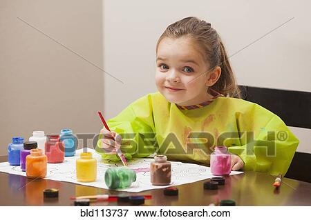 Caucasian girl painting at table View Large Photo Image Stock Photo - Caucasian girl painting at table. Fotosearch