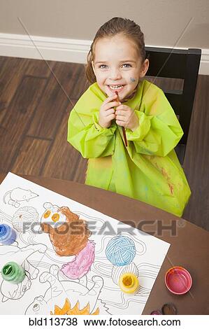 Stock Photo - Caucasian girl painting at table. Fotosearch