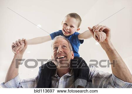 Caucasian man carrying son on shoulders View Large Photo Image Stock Photo - Caucasian man carrying son on shoulders. Fotosearch