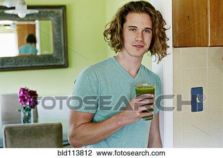 Stock Image - Caucasian man having glass of juice. Fotosearch