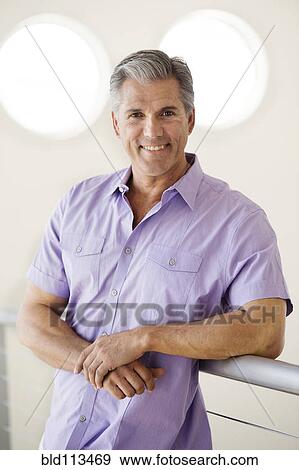 Stock Photo - Caucasian man leaning on banister. Fotosearch