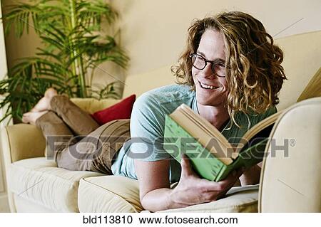 Caucasian man reading on sofa View Large Photo Image Stock Image - Caucasian man reading on sofa. Fotosearch