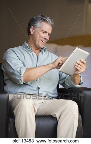 Stock Image - Caucasian man using tablet computer. Fotosearch