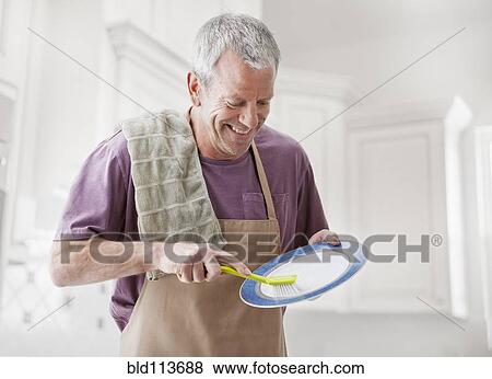 Caucasian man washing dishes in kitchen View Large Photo Image Stock Photo - Caucasian man washing dishes in kitchen. Fotosearch
