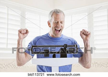 Caucasian man weighing himself View Large Photo Image Stock Image - Caucasian man weighing himself. Fotosearch