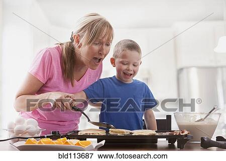Caucasian mother and son cooking breakfast View Large Photo Image Stock Photo - Caucasian mother and son cooking breakfast. Fotosearch