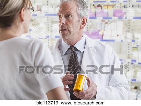 Stock Photo - Caucasian pharmacist talking to patient. Fotosearch