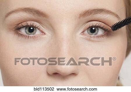 Stock Image - Caucasian woman applying mascara. Fotosearch