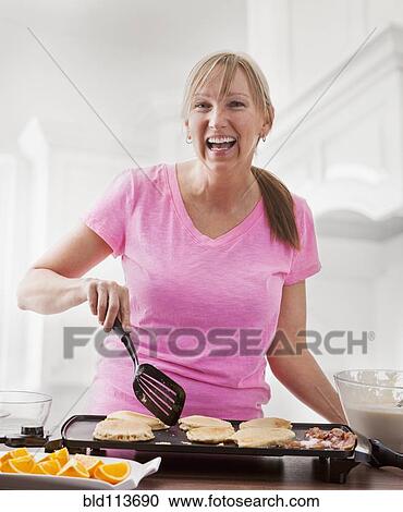 Caucasian woman cooking breakfast View Large Photo Image Stock Image - Caucasian woman cooking breakfast. Fotosearch