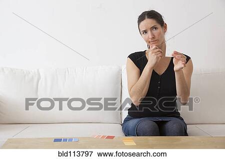 Stock Photo - Caucasian woman examining paint swatches. Fotosearch
